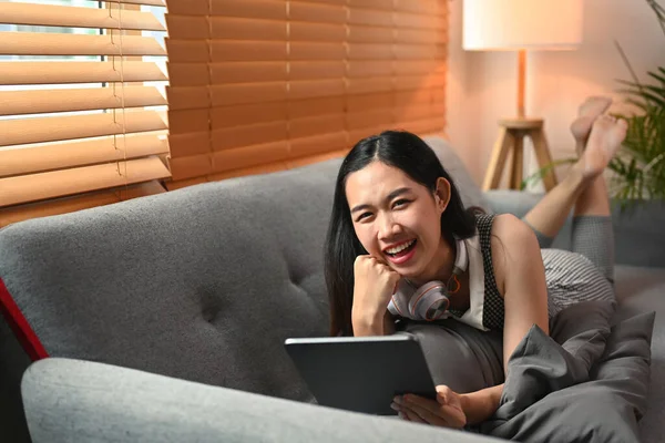 Glada Kvinna Som Håller Digital Tablett Och Ligger Soffan — Stockfoto