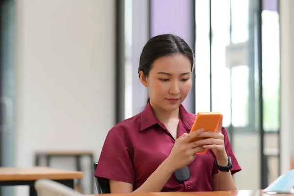在办公室用智能手机的年轻亚洲女人 — 图库照片