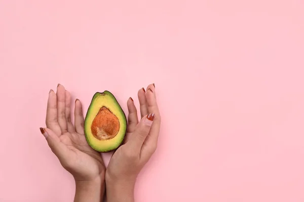 Vrouw Met Avocado Roze Achtergrond Gezond Fruitconcept — Stockfoto