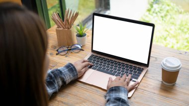 Kafede bilgisayar laptopuyla çalışan serbest çalışan bir kadın..