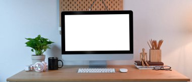 Bilgisayarlı rahat iş yeri, ev bitkisi ve malzemeler ahşap masada..