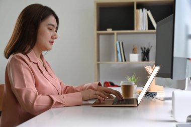 Evde bilgisayarla çalışan genç bir kadın..