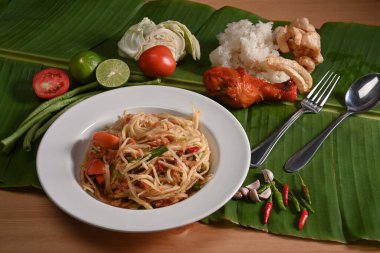 Kızarmış tavuklu Papaya salatası ve muz yaprağında yapışkan pirinç. Tayland Gıda Konsepti.