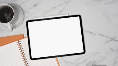 Dijital tabletin, not defterinin ve kahve fincanının üzerinde mermer arka plan.