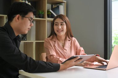 İş adamları dijital tablet üzerinde iş verilerini tartışıyor.