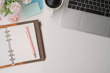 Dizüstü bilgisayarı, defteri ve kahve fincanı olan en iyi ofis masası..