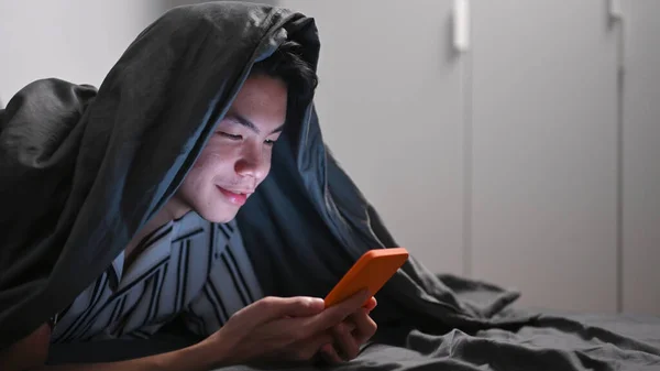 Азиатский Мужчина Лежит Кровати Поздно Ночью Помощью Мобильного Телефона — стоковое фото