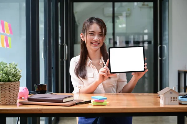Dijital tableti boş ekranla tutan ve gösteren neşeli genç bayan..