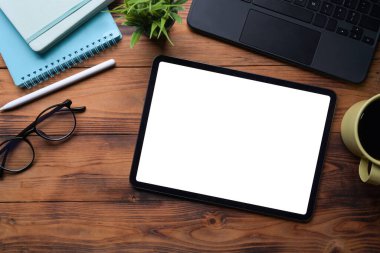 Üst görünüm dijital tablet, stilus kalem, kahve fincanı ve defter ahşap masa üzerinde..