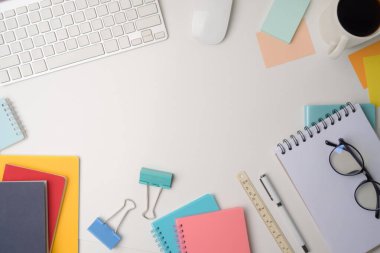 Not defteri, yapışkan notlar ve kahve fincanı olan beyaz ofis masası..