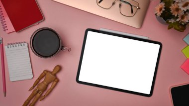 Üst görünüm dijital tablet, kahve fincanı, bardaklar ve pembe arkaplan üzerine not defteri.