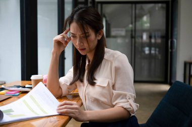 Ofisteki evrak işlerini inceleyen ciddi bir kadın ofis çalışanı..