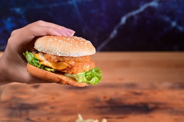 Lezzetli kızarmış balık burgeri tutan kadın..