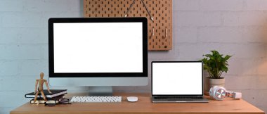 Ahşap masa üzerinde modern aletleri ve malzemeleri olan yaratıcı bir iş yeri..