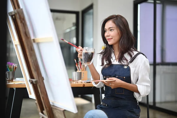 魅力的な女性画家は キャンバス上のコーヒーや絵画の画像を飲む — ストック写真
