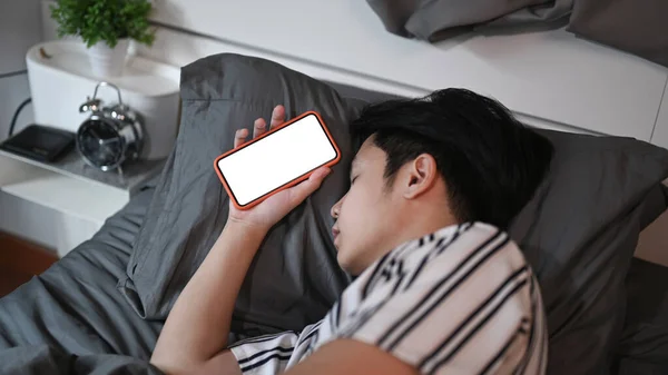 Azji Człowiek Zasypia Smartfonem Ręku Nocy Łóżku — Zdjęcie stockowe