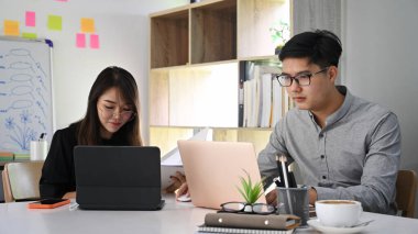 İki iş adamı bir projede birlikte çalışıyor ve modern ofiste oturuyorlar..