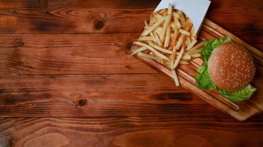 Ev yapımı hamburger ve kızarmış patatesler üzerinde fotokopi alanı olan ahşap masa..