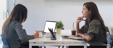 İki yaratıcı kadın tasarımcı ofiste birlikte oturup yeni projelerini tartışıyorlar..