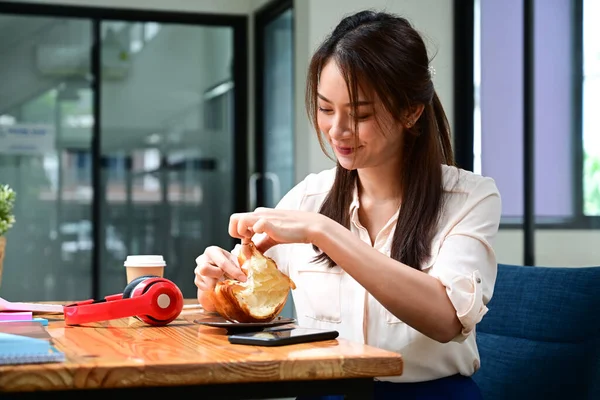 Νεαρή Ασιάτισσα Τρώει Πρωινό Στο Γραφείο Της — Φωτογραφία Αρχείου