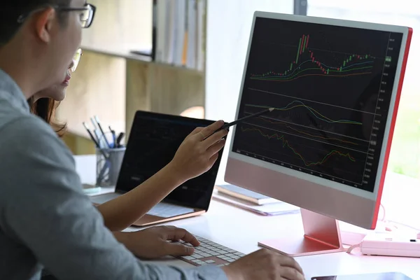 商人们一起在电脑屏幕上分析财务数据图 — 图库照片