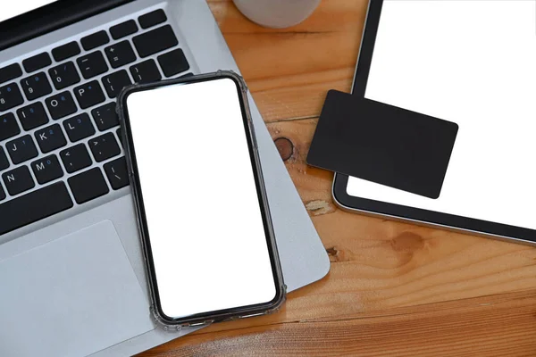 Akıllı telefon, dizüstü bilgisayar, dijital tablet ve kredi kartını ofis masasına yerleştir.