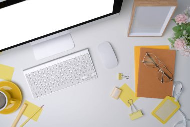 Bilgisayar bilgisayarı ve ofis malzemeleri beyaz masada..