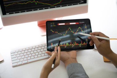 Dijital tablet üzerindeki istatistikleri analiz eden iki işadamı.