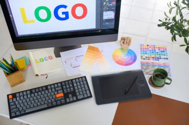 Markalaşma projesi devam eden grafik tasarım çalışma istasyonunun üst görünümü.