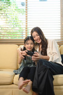 Anne kızına oyun oynamayı öğretiyor, kahkahaları paylaşıyor ve eğlenceli dijital oyun saatleriyle öğreniyor..