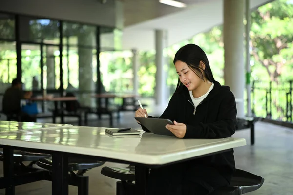 Z Geni lise öğrencisi, dijital tablet ve stilus ile doğal ışık altında açık hava sınıfında ders çalışıyor...