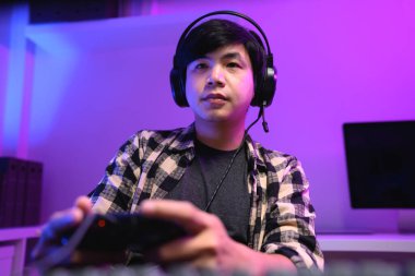 Sakin oyuncu geceleri kulaklık ve neon RGB ışıklandırmasıyla video oyunu oynamaya odaklandı.