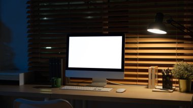 Ofis malzemeleriyle birlikte huzurlu bir gece çalışma alanında bilgisayar masasında..