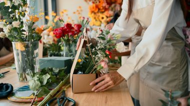 Yakından insanlar yaratıcı bir atölyede çiçek düzenlemeyi öğreniyorlar, takım çalışması ile renkli buketler yapıyorlar..