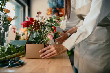 Yakından insanlar yaratıcı bir atölyede çiçek düzenlemeyi öğreniyorlar, takım çalışması ile renkli buketler yapıyorlar..