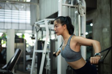 Kablolu göğüs pres makinesi, spor ve spor konsepti üzerinde göğüs egzersizi yapan bir kadın..