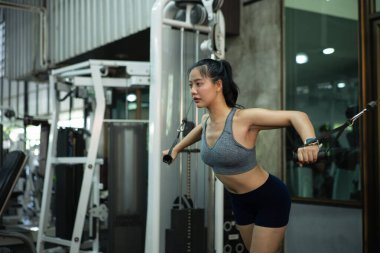 Kablolu göğüs pres makinesi, spor ve spor konsepti üzerinde göğüs egzersizi yapan bir kadın..