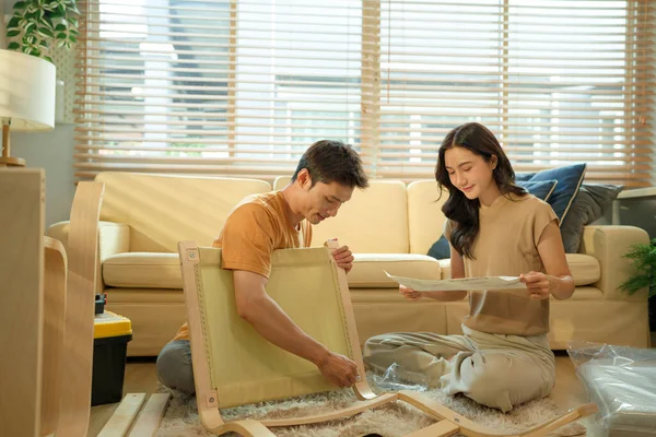 Asyalı genç çiftin fotoğraf serisi evde yeni bir mobilya montajı.