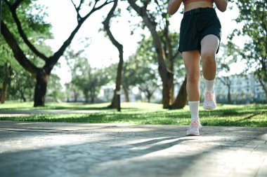 A-Skips sprint antrenmanı yapan bir kadın açık havada egzersiz yapıyor..