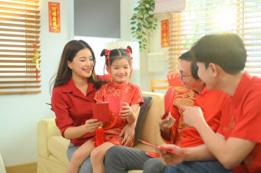 Asyalı büyükanne ve büyükbaba, Çin Yeni Yıl Aile Toplantısı 'nda torunlarına kırmızı zarf veriyorlar..