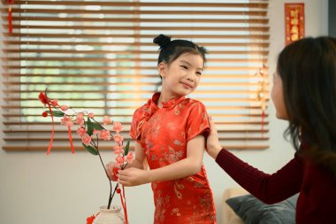 Anne ve kızı, Çin Yeni Yılı için kırmızı kayısı çiçeği süslemişler..