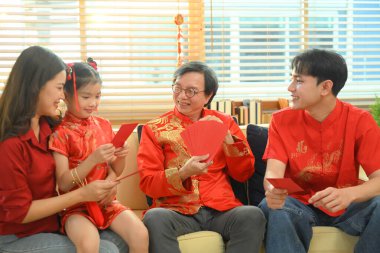 Asyalı büyükanne ve büyükbaba, Çin Yeni Yıl Aile Toplantısı 'nda torunlarına kırmızı zarf veriyorlar..