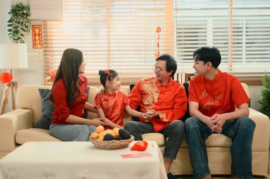 Çin Yeni Yılı boyunca yaşlı bir akrabasını ziyaret eden aile, nesiller boyu gülümseme ve sıcak sohbetlerini paylaşıyor..