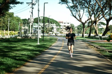Şehir parkında koşan sporcu kadın..