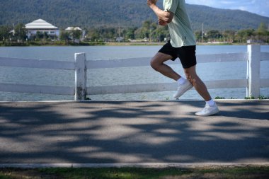 Kırpılmış atış koşucusu park ve dağ manzarasında koşuyor, Yeni Yıl Sağlık Hizmetleri.