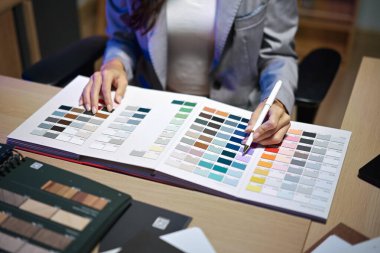 İç mimar ofisteki yeni ev projesinde çalışıyor. Örneklerden malzeme ve renk seçmek.