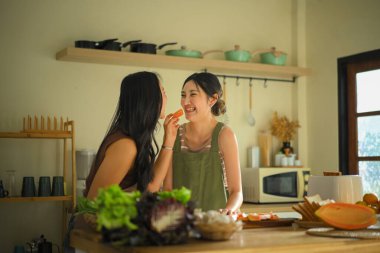 LGBT çifti sıcacık bir mutfakta taze papaya paylaşıyor, sağlıklı yemek hazırlarken birlikte gülümsüyor ve evde sıcak, samimi bir sabah geçiriyorlar..