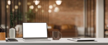 3 boyutlu dizüstü bilgisayarı beyaz masaya yerleştir. Yakınlarda kağıt, kalem tutacağı var. Modern ofis işyerinde.