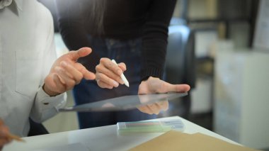 Çeşitli iş arkadaşları yönetim kurulunda birlikte çalışıyor. Dijital tabletle beyin fırtınası yapıyor, tartışıyor ve analiz ediyorlar..