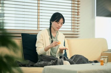 Kanepede ilaç alan bir kadın..